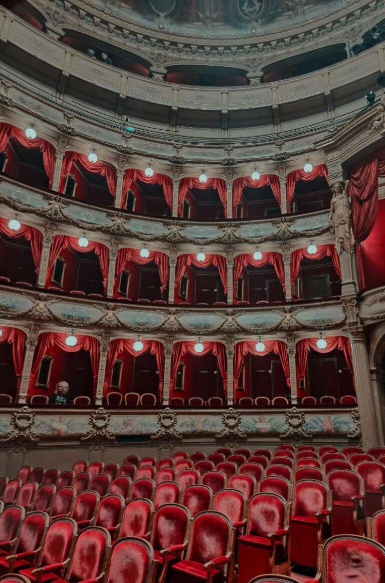 Elegant theatre interior with red velvet seats and ornate balconies