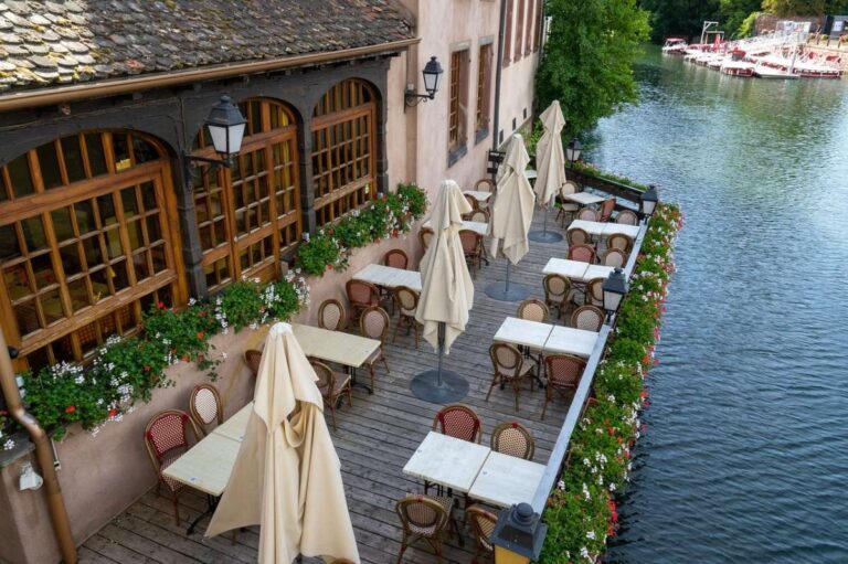 Outdoor restaurant terrace overlooking a river with decorative flowers