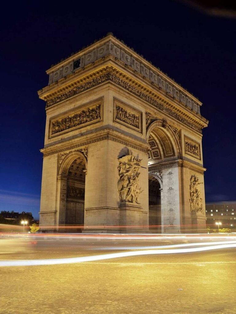 Paris’s Arc de Triomphe illuminated at night with streaks of car lights