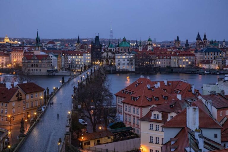 Twilight view of Prague's Charles Bridge over a calm river