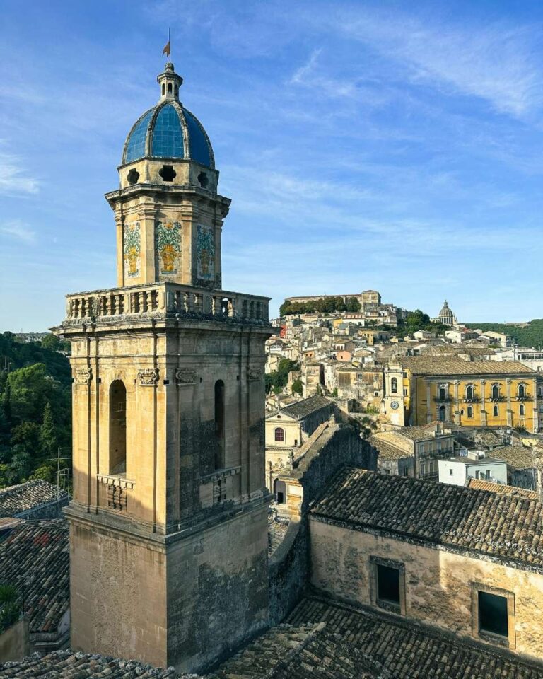 Historic church tower surrounded by lush greenery