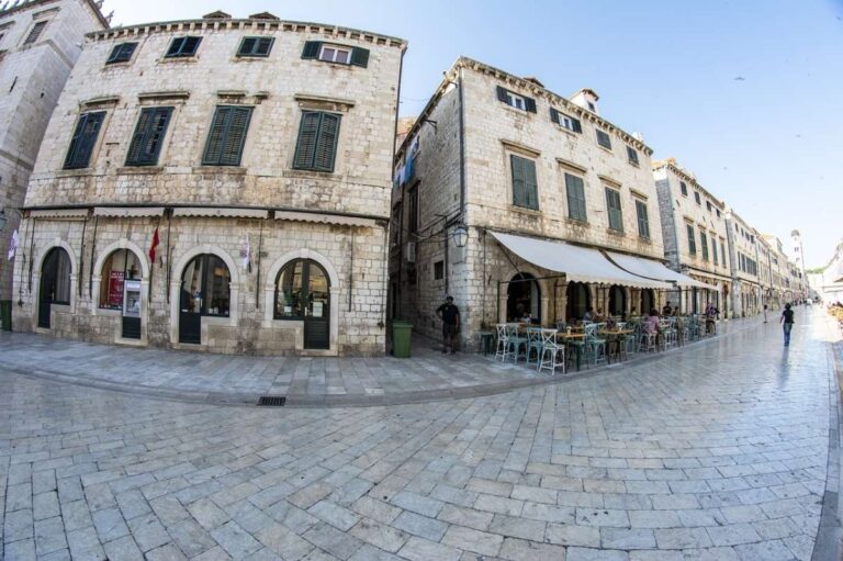 Outdoor cafe and shops in a historic square with stone buildings