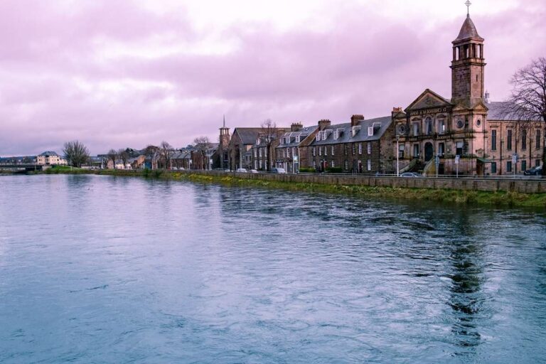 Charming riverside view of a town in Inverness with traditional buildings