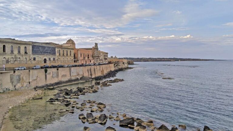 Scenic sea walk in Siracusa with historic buildings along the shore