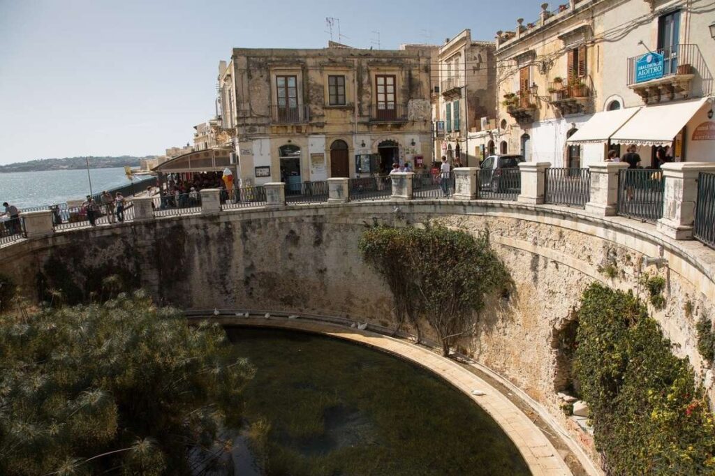 Cliffside walk in Siracusa overlooking the rocky shoreline and sea