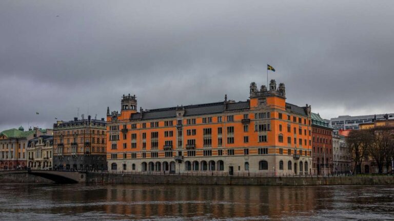 A historic building along the river in Stockholm under a gray sky