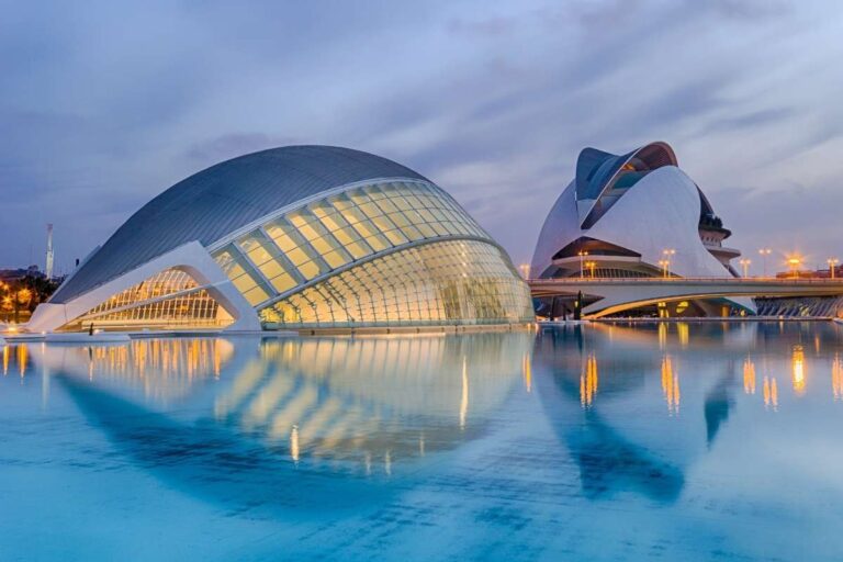 Futuristic buildings reflected in the calm water at sunset in Valencia