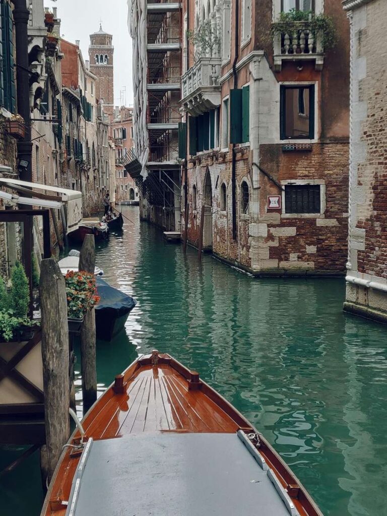 A gondola in a narrow Venetian canal lined with historic buildings