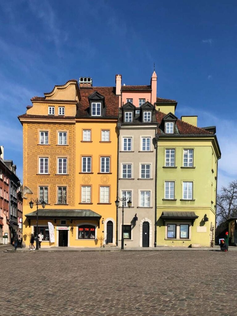 Colorful townhouses on Warsaw's main square under a blue sky