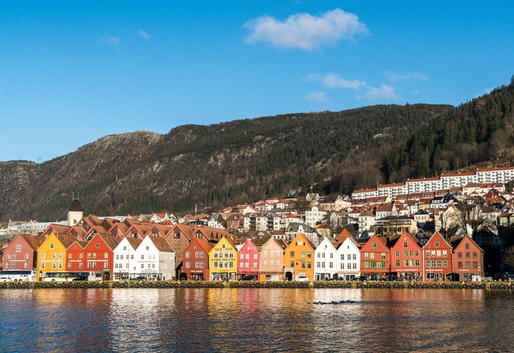 Sea view of Bergen with promenade, the Bryggen House and mountains in the back