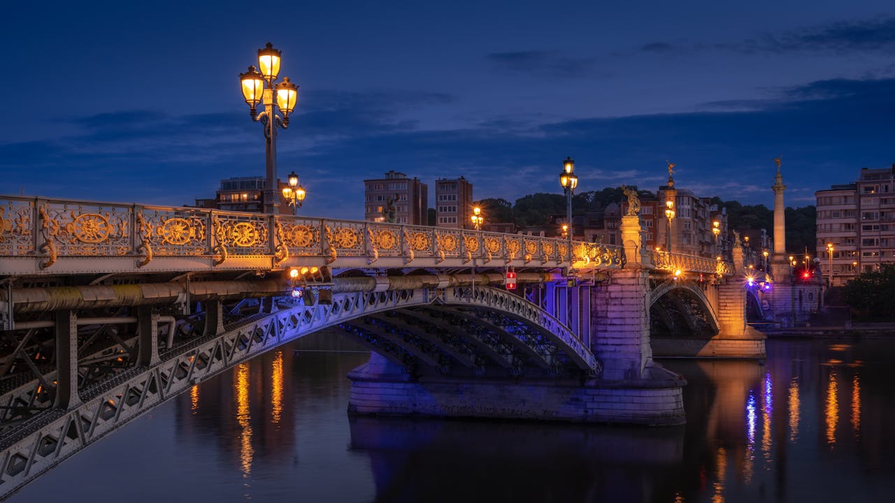 a bridge in Liege in Belgium over the Meuse river at night with lights