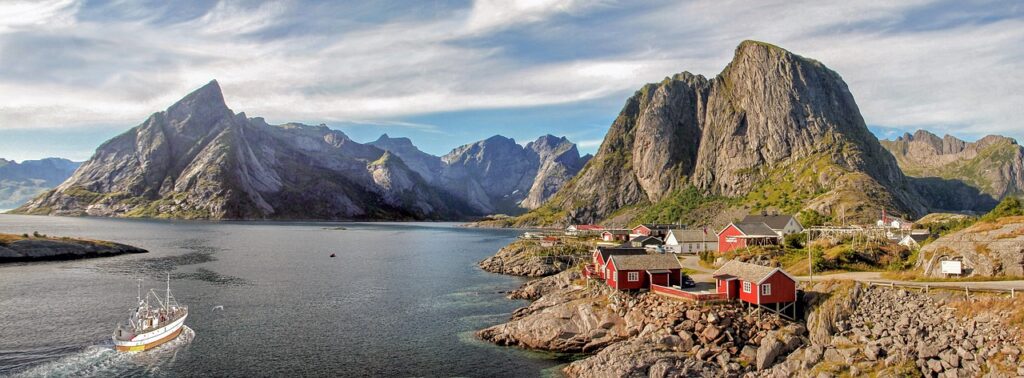 islands of Lofoten in Norway with typical red houses and mountains in the background