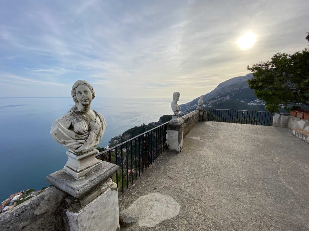 a statue on a terrace overlooking a body of water at the Amalfi coast