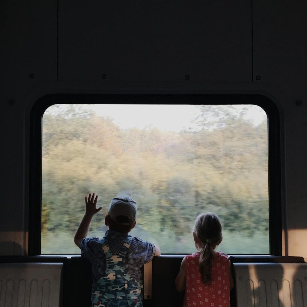 kids looking out of a train window during their ride