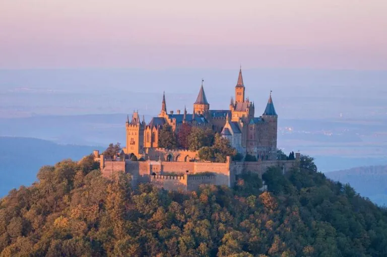 Hohenzollern Castle in Stuttgart at sunrise, surrounded by mist and hills