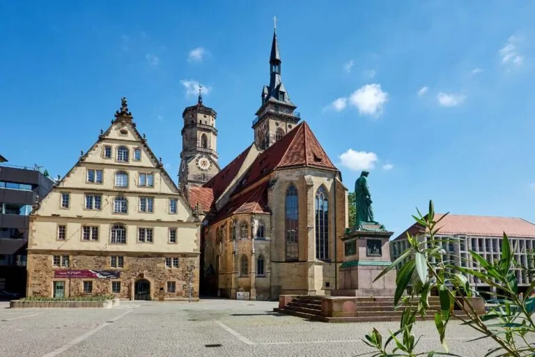 Sunny Stuttgart square with a historic church and vibrant foliage