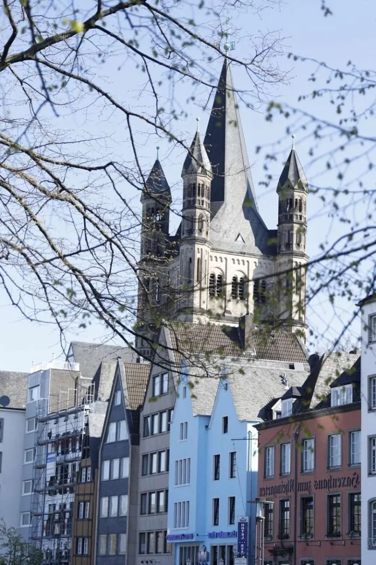 Historic buildings in Cologne with a towering church spire in the background